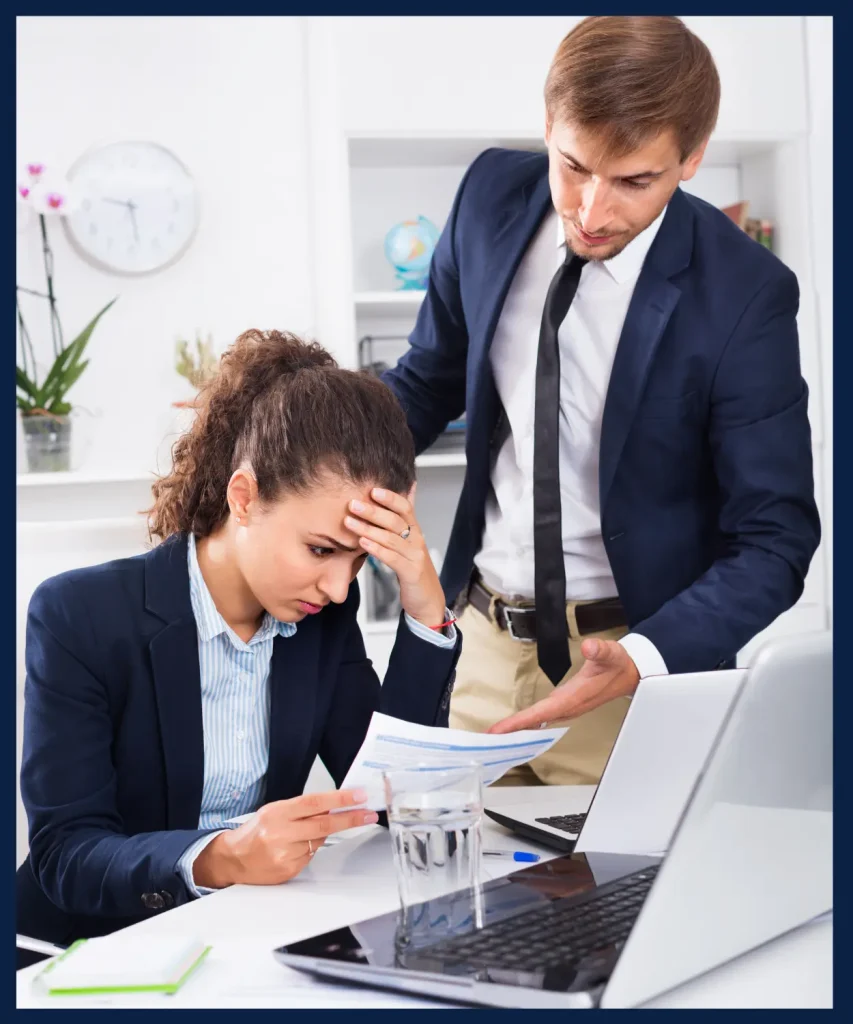 A stressed businesswoman and her colleague reviewing documents, representing Costaras Law’s expertise in handling complex legal disputes.