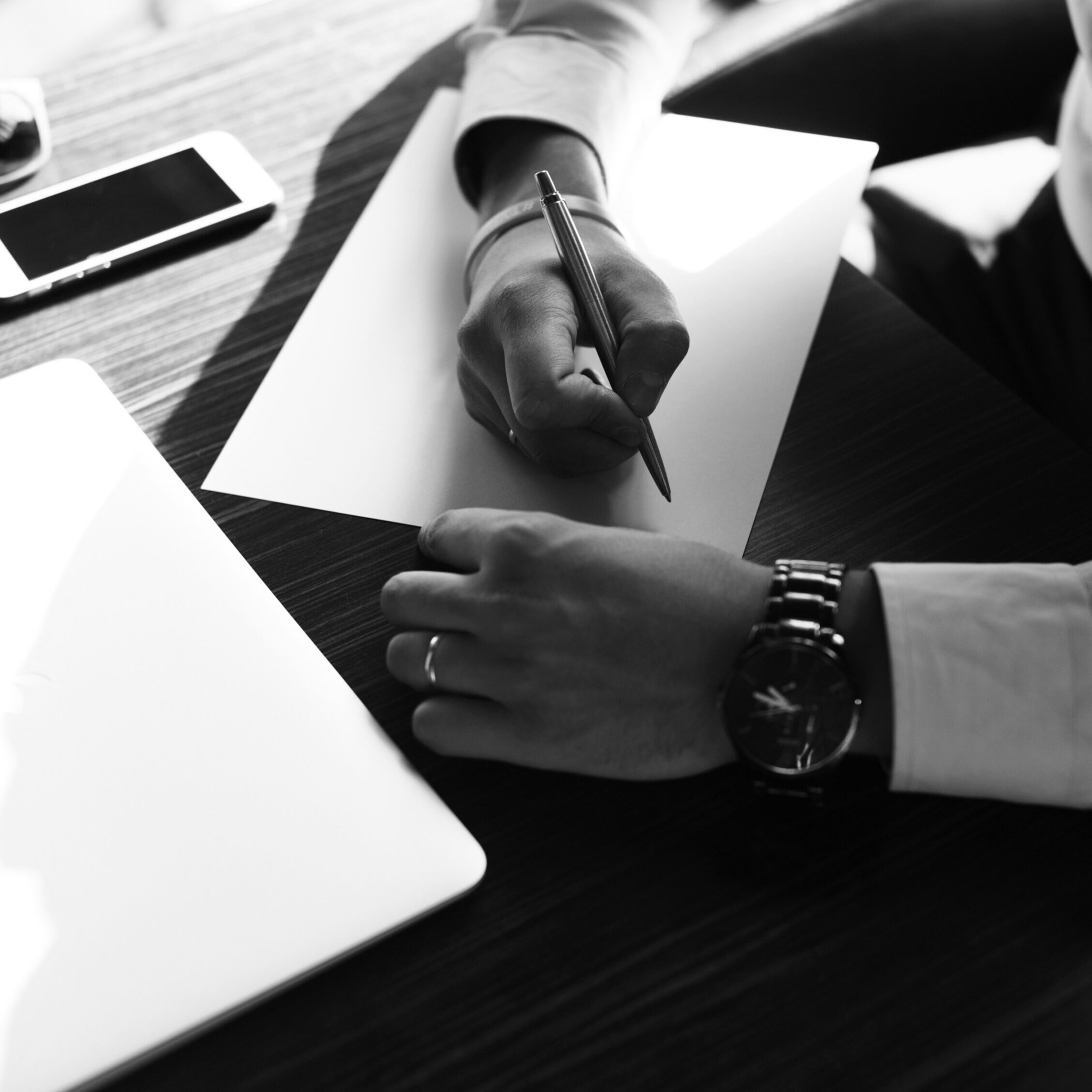 Close-up of a professional signing documents at a desk, illustrating common legal mistakes in business agreements and contract handling.